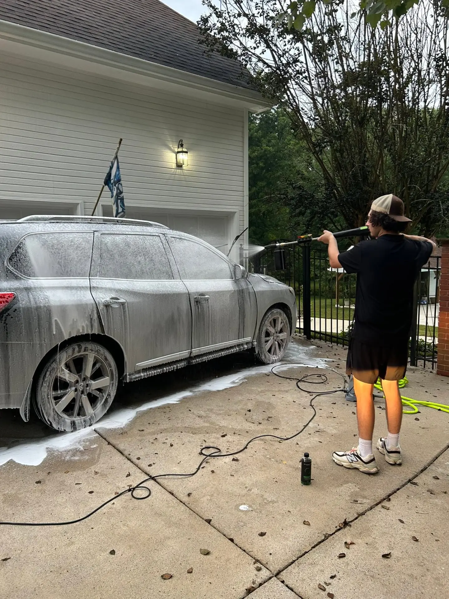 SixPoint Detailing foam washing a Nissan Pathfinder in the driveway