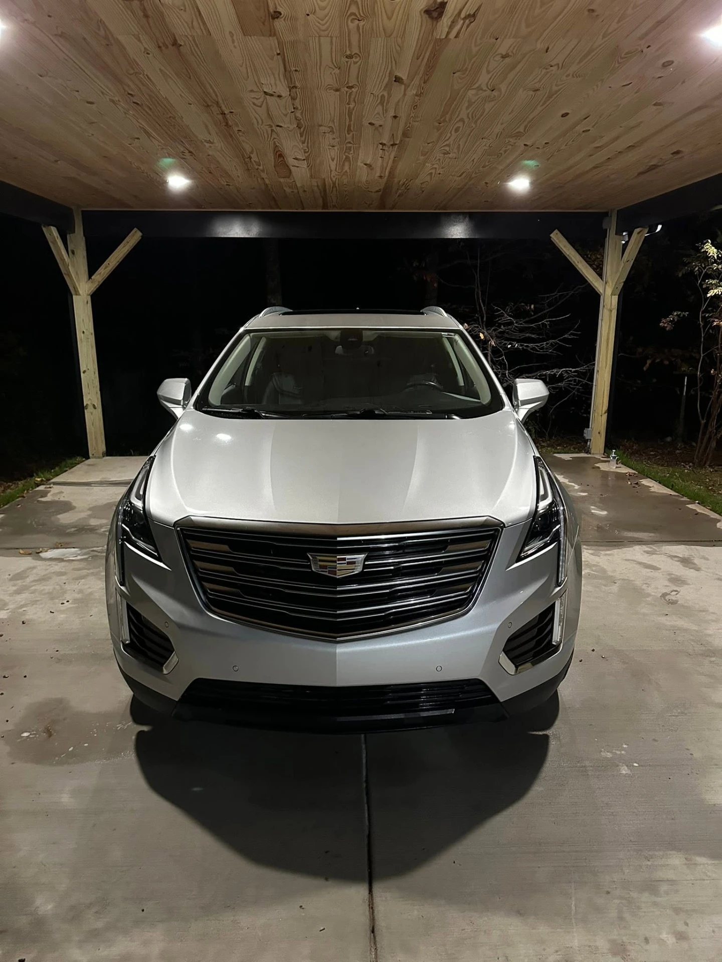 Silver Cadillac XT5 front after detail under carport at night